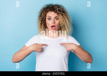 Foto di una pazza che si dirige con il dito incredibile reazione di Pick indossa una camicia casual sfondo blu isolato Foto Stock