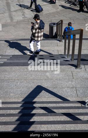 Uomo con giacca a plaid in piedi alle scale dal piazzale della stazione alla cattedrale, Colonia, Germania. Mann mit karrierter Jacke steht an der tre Foto Stock