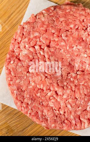 Hamburger di manzo crudo con erba pronti per la cottura Foto Stock