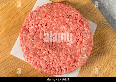 Hamburger di manzo crudo con erba pronti per la cottura Foto Stock