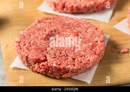 Hamburger di manzo crudo con erba pronti per la cottura Foto Stock