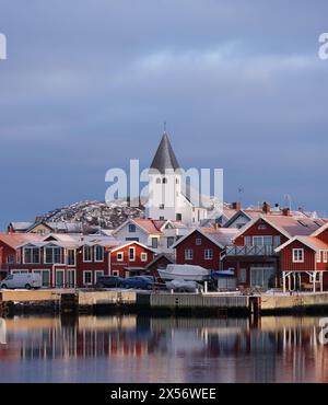 Skaerhamn, Svezia - 10 dicembre 2022: Vista del villaggio di pescatori di Skaerhamn in inverno con case, chiesa e porto. Nessuna persona visibile Foto Stock