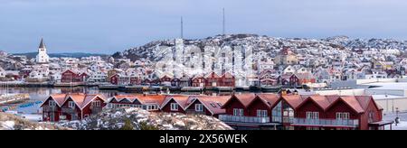 Skaerhamn, Svezia - 10 dicembre 2022: Vista del villaggio di pescatori di Skaerhamn in inverno con case, chiesa e porto. Nessuna persona visibile Foto Stock