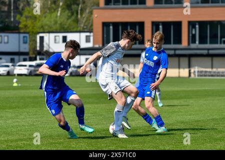 Landore, Swansea, Galles. 7 maggio 2024. Harlan Perry dello Swansea City sotto la pressione di due giocatori del Cardiff City durante la partita Under 18 Professional Development League tra Swansea City e Cardiff City alla Swansea City Academy di Landore, Swansea, Galles, Regno Unito, il 7 maggio 2024. Crediti: Duncan Thomas/Majestic Media/Alamy Live News. Foto Stock