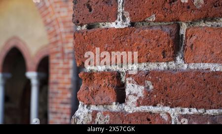 Antica struttura della facciata in mattoni rossi - il frammento di parete ad arco in una vista ravvicinata costruita nell'edificio medievale della Cattedrale di riga, la capitale della Lettonia. Foto Stock