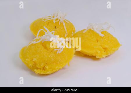 Giallo vivace Thai Toddy Palm Cakes o Khanom Tan, con cocco grattugiato su sfondo bianco Foto Stock