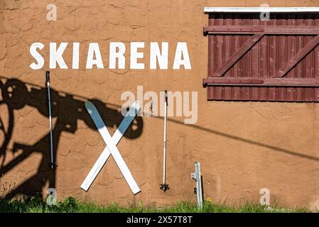 Stazione di montagna degli impianti di risalita, ombra dei meccanismi delle ruote e della fune, casa della stazione con pali da sci e sci in estate, pista da sci, cima Foto Stock