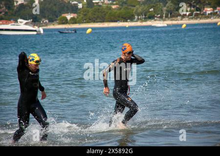 Sabaris, Baiona, Pontevedra, Spagna; 15 luglio, 2023; i concorrenti del triathlon emergono dall'acqua con le loro mute Foto Stock