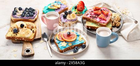 Colazione dolce con tazza di cacao. Toast con formaggio spalmabile, banana, fragole, mirtilli. Panorama Foto Stock