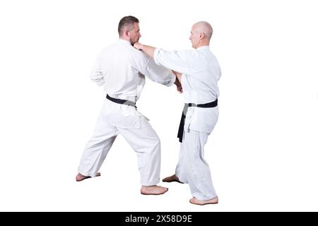 L'atleta adulto esegue esercizi formali di goju-ryu. È isolato su uno sfondo bianco. Primo piano. Foto Stock