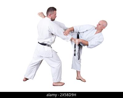 L'atleta adulto esegue esercizi formali di goju-ryu. È isolato su uno sfondo bianco. Primo piano. Foto Stock