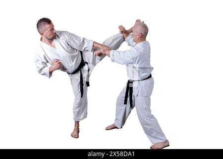 L'atleta adulto esegue esercizi formali di goju-ryu. È isolato su uno sfondo bianco. Primo piano. Foto Stock