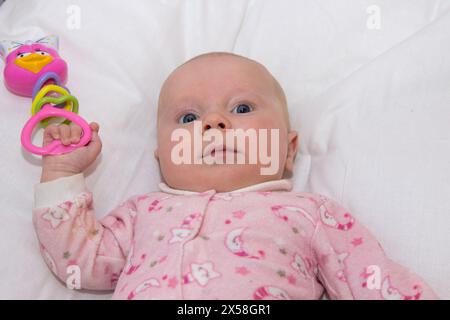 il bambino sta giocando un giocattolo in una culla Foto Stock