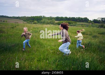 una madre gioca a recuperare le sue figlie Foto Stock