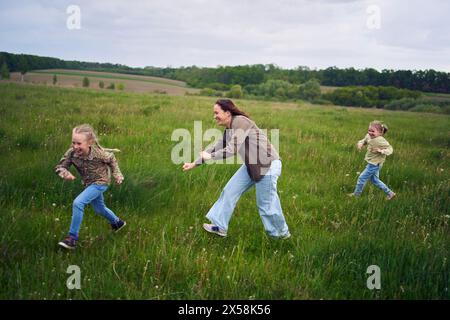 una madre gioca a recuperare le sue figlie Foto Stock