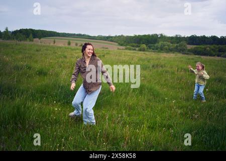 una madre gioca a recuperare le sue figlie Foto Stock