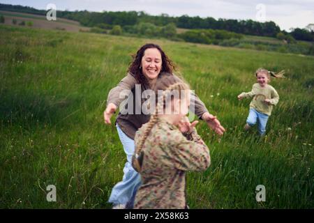 una madre gioca a recuperare le sue figlie Foto Stock