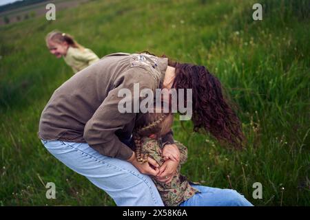 una madre gioca a recuperare le sue figlie Foto Stock