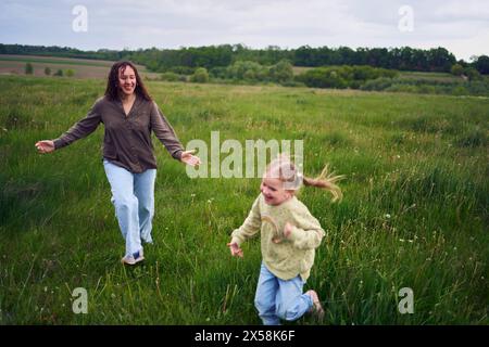 una madre gioca a recuperare le sue figlie Foto Stock