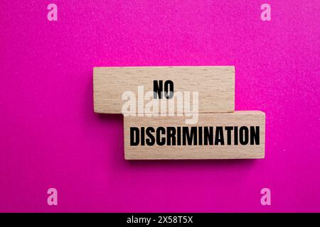 Nessuna discriminazione scritta su blocchi di legno con sfondo rosa. Simbolo concettuale di non discriminazione. Copia spazio. Foto Stock