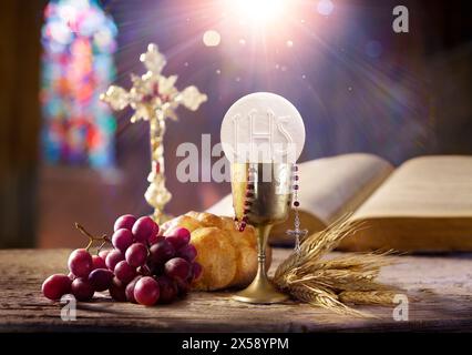 Comunione in Santa messa - Graal con Pane e Calice del vino - ultima cena con Corpus Domini e luce del sole Foto Stock