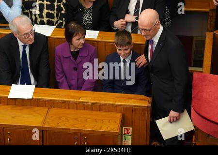 John Swinney (a destra) patta suo figlio Matthew, 13 anni, sulla spalla, sorvegliato da suo fratello David Swinney e dalla moglie Elizabeth Quigley mentre arriva per giurare come primo ministro di Scozia e custode del sigillo scozzese, alla Court of Session di Edimburgo. Data foto: Mercoledì 8 maggio 2024. Foto Stock