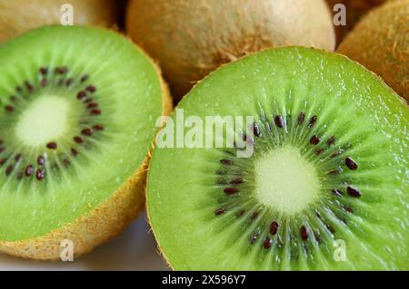 Primo piano di frutta Kiwi matura fresca sezioni trasversali con frutta intera sullo sfondo Foto Stock