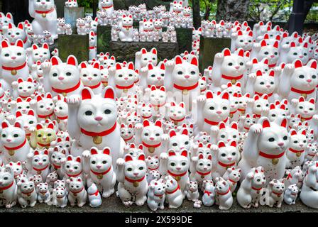Statue di Maneki-neko "attiranti gatto" presso il famoso santuario dei gatti, il Tempio di Gotokuji a Tokyo Foto Stock