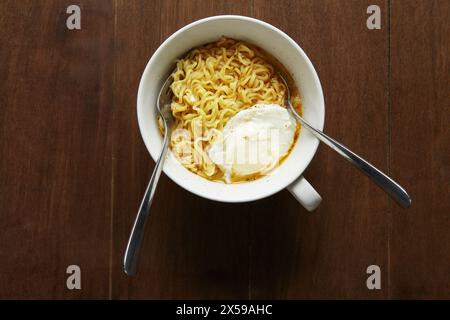 L'aspetto originale di spaghetti istantanei e uova bollite cotte in casa in un recipiente senza piegare il cibo Foto Stock