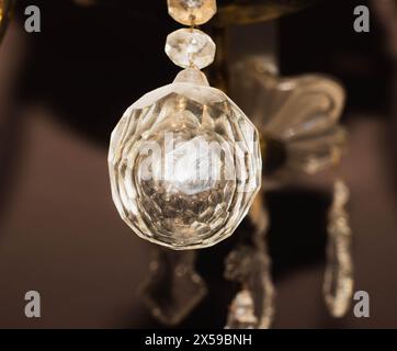 Una sfera di cristallo è appesa al lampadario. Dettagli del lampadario di cristallo, primo piano Foto Stock