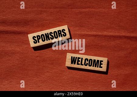Gli sponsor accolgono le parole scritte su blocchi di legno con sfondo marrone. Simbolo commerciale concettuale. Copia spazio. Foto Stock