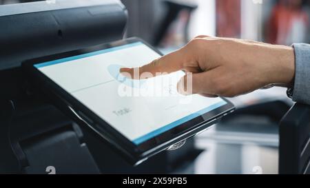 Close Up Shot of a Person Touching an Electronic Fingerprint Recognition Feature on a Digital Screen in Order to Make a Purchase in a Clothing Store. Customer Buying Items in Shop with Digital ID. Foto Stock