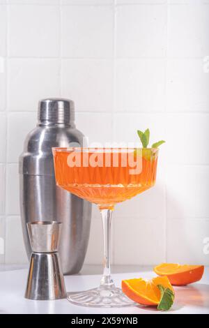 Classico aperitivo italiano cocktail martini aperol spritz in bicchiere con cubetti di ghiaccio, alcool dolce lungo bevanda alcolica con fetta di arancia e menta, su wh Foto Stock