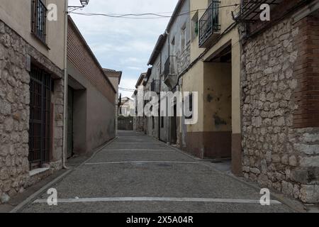 strada acciottolata, vecchi edifici strutturati, cielo nuvoloso, tranquilla città storica, senza pedoni, stringhe di luci Foto Stock