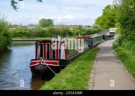 Tre barche strette ormeggiate lungo un sentiero a schiera, vicino a un ponte sul canale Llangollen vicino a Ellesmere nello Shropshire in una giornata di sole primaverili. Foto Stock