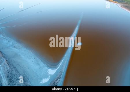 Uno scatto aereo che cattura la bellezza serena delle lagune di sale vicino a Toledo, riflettendo le sfumature del tramonto nelle acque tranquille Foto Stock