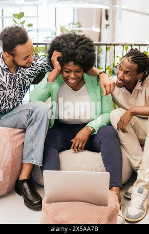 Tre giovani professionisti partecipano a una sessione di brainstorming informale, condividendo idee in un ambiente di coworking felice e amichevole Foto Stock