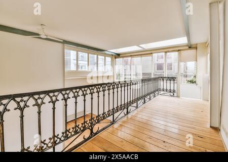 Spazio interno luminoso e arioso, con pavimenti in legno duro, ringhiere per balconi ornate e ampie finestre che lasciano entrare luce naturale. Foto Stock