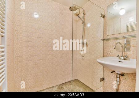 Questa immagine presenta un bagno moderno e ben illuminato con piastrelle a motivi geometrici che coprono le pareti e una spaziosa area doccia. Foto Stock