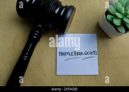 Il concetto di Fahrlehrer gesetz scrive su appiccicose note isolate su un tavolo di legno. Foto Stock