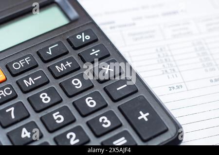 Primo piano di una calcolatrice, di un dispositivo di input periferico, sopra un foglio di carta, di un'apparecchiatura da ufficio spesso utilizzata con una tastiera per computer o un personal com Foto Stock