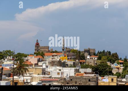 Rodi, Grecia - 12 giugno 2023: Palazzo dei cavalieri ospedalieri ed edifici nella città vecchia visti dalla cima delle mura della città. La torre della chiesa e la torre del minareto, ma Foto Stock