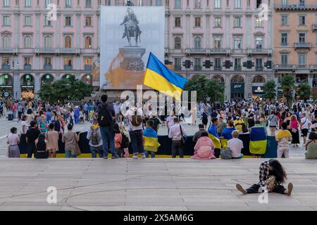Milano, Italia - luglio 27 2023: Raduno pubblico a sostegno dell'Ucraina in piazza di fronte alla cupola. Uomo con bandiera ukraniana. Ragazza seduta a terra, sle Foto Stock