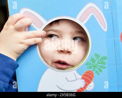 bambino che gioca con ritagli colorati di vari animali Foto Stock