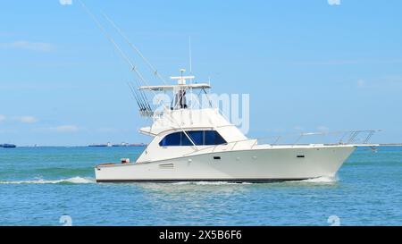 PORT ARANSAS, TX - 29 FEB 2020: Vista panoramica di uno splendido yacht da pesca bianco naviga sulle calme acque blu mentre si avvicina al porticciolo su una S. Foto Stock