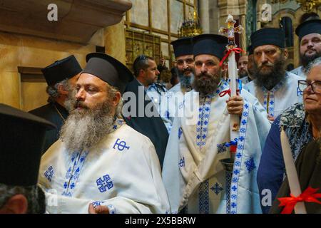 L'entourage del Patriarca greco entra nella Chiesa del Santo Sepolcro. La cerimonia del Santo fuoco è celebrata dalle chiese ortodosse nella Chiesa del Santo Sepolcro di Gerusalemme ogni anno prima della Pasqua. Questo evento spirituale e religioso è uno dei rituali più importanti del cristianesimo ortodosso e molti pellegrini si riuniscono da tutto il mondo per testimoniarlo. Durante la cerimonia il Patriarca greco entra nelle edicole dove si trova la tomba di Gesù, pregando fino a quando si crede che il fuoco santo sia acceso dallo Spirito Santo. La folla della chiesa aspetta fuori con ansia di testimoniare Foto Stock