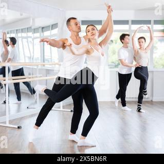 Ballerina di balletto che fornisce supporto alla partner femminile in movimenti impegnativi Foto Stock