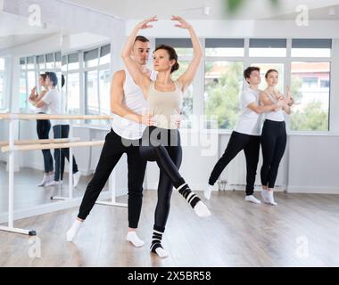 Ballerina di balletto che fornisce supporto alla partner femminile in movimenti impegnativi Foto Stock