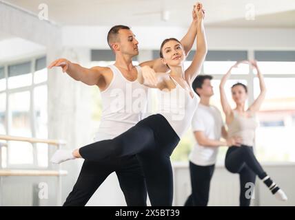 Ballerina di balletto che fornisce supporto alla partner femminile in movimenti impegnativi Foto Stock