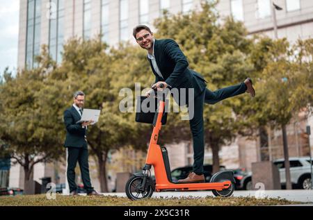 Affari pazzi, veloci e facili. Scooter consente agli uomini d'affari di essere efficienti e puntuali. Lo scooter elettrico offre una soluzione di trasporto facile e veloce Foto Stock